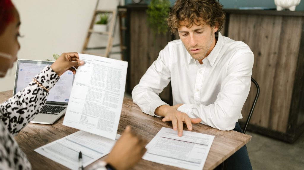 rendez-vous de travail autour de documents imprimés, ordinateur portable ouvert sur la table